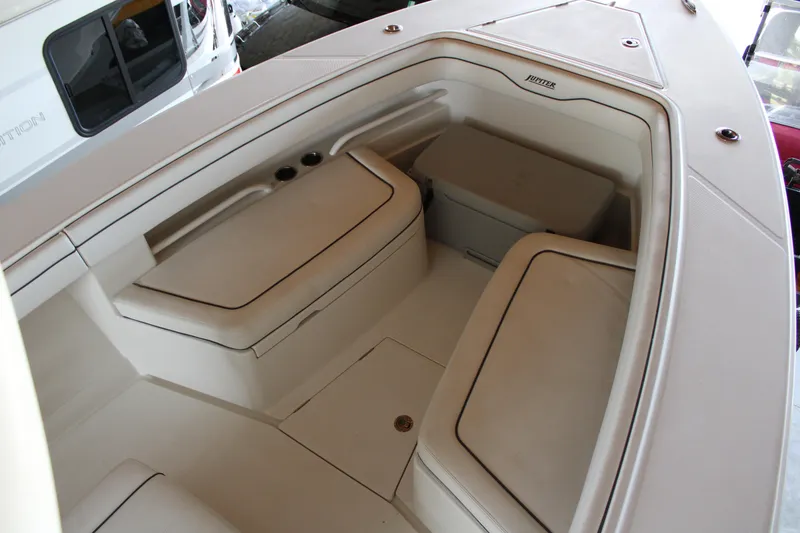 Slide: The Image of Interior view of 2018 Jupiter 30 HFS boat, featuring cushioned seating and storage. - 18