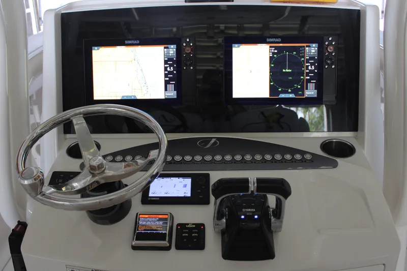 Slide: The Image of Control panel of a 2018 Jupiter 30 HFS boat with navigation screens and steering wheel. - 5