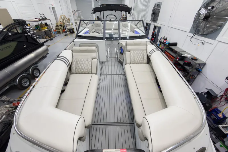 Slide: The Image of 2020 Crest Continental 270 NX-L Twin pontoon boat interior with luxurious seating in a workshop. - 11