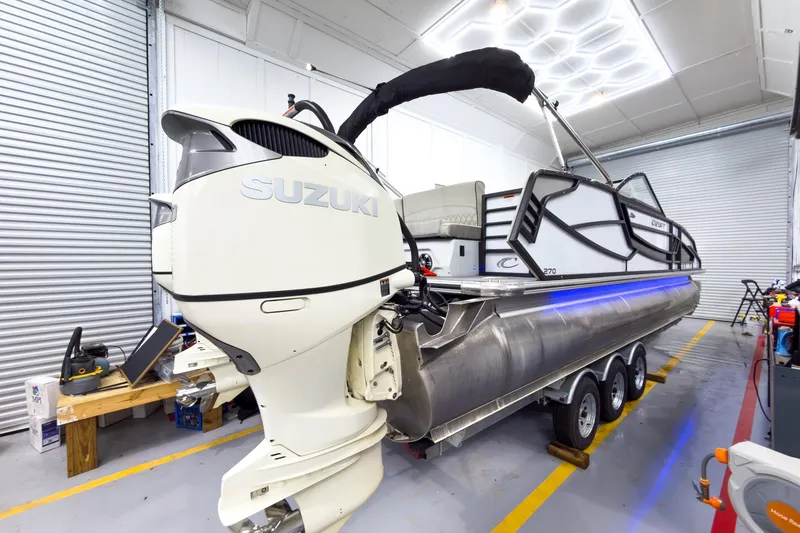 Slide: The Image of 2020 Crest Continental 270 NX-L Twin boat with Suzuki engine in a garage. - 6