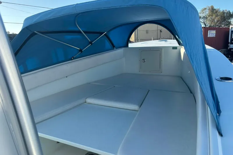 Slide: The Image of 2014 Andros Tarpon 26 boat with blue canopy and spacious seating area. - 11