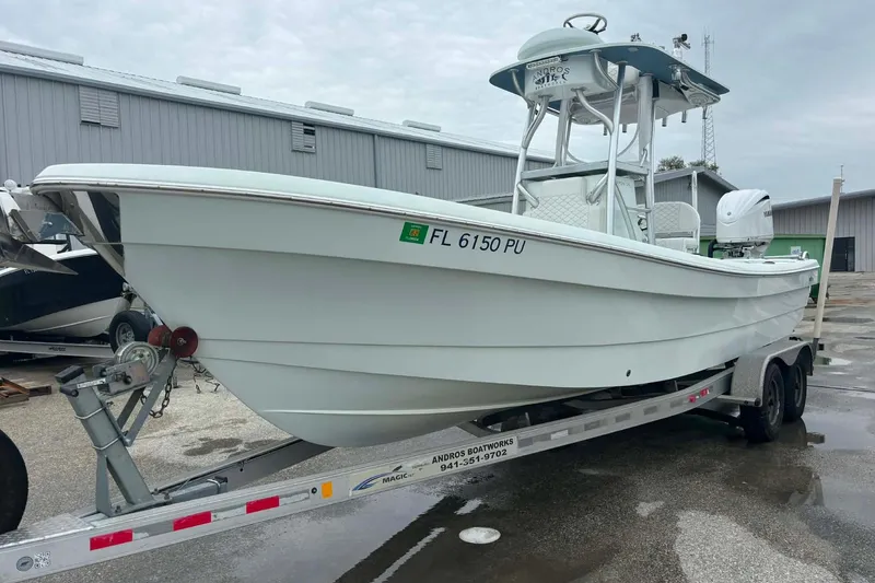 Slide: The Image of 2014 Andros Tarpon 26 boat on trailer, parked outside a warehouse. - 5