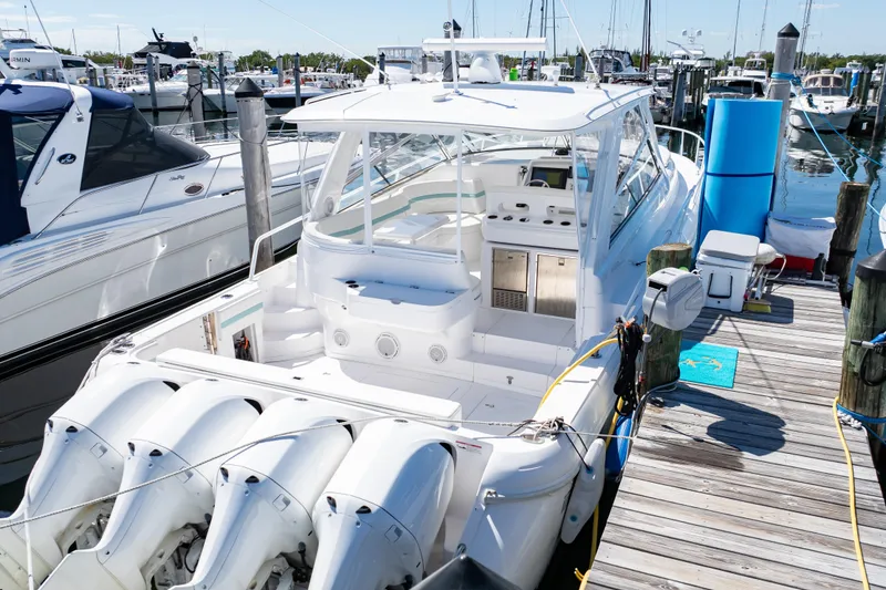 Slide: The Image of 2018 Intrepid 475 Sport Yacht docked at marina with multiple outboard engines. - 10