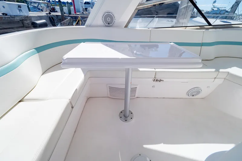 Slide: The Image of 2018 Intrepid 475 Sport Yacht interior with white seating and table. - 109