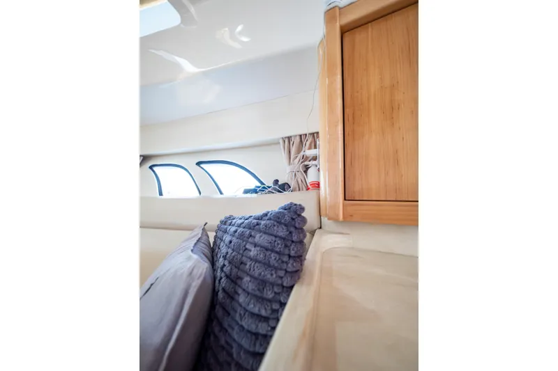 Slide: The Image of Interior of 2018 Intrepid 475 Sport Yacht with plush pillows and wooden cabinetry. - 115