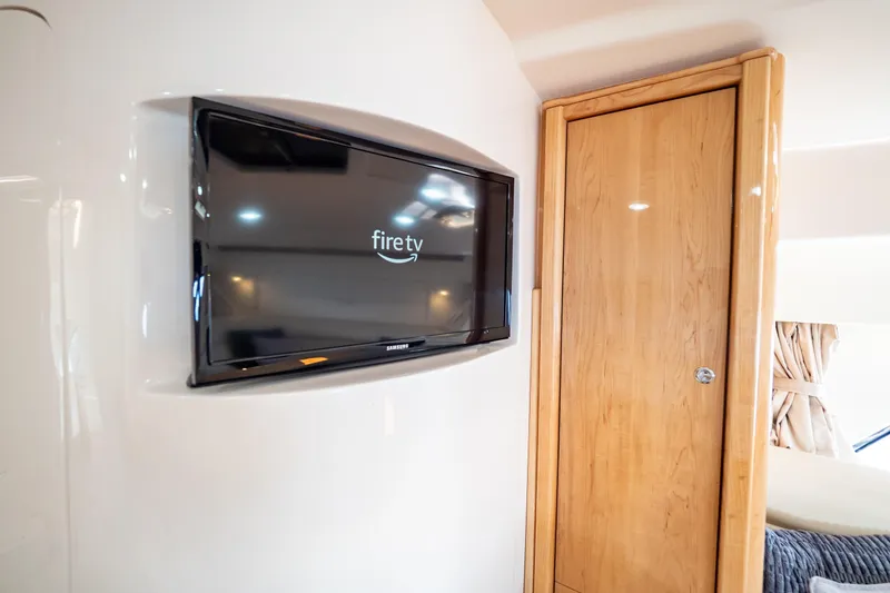 Slide: The Image of 2018 Intrepid 475 Sport Yacht interior with Fire TV and wooden cabinet. - 123