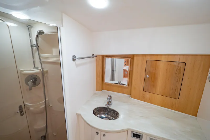 Slide: The Image of Luxurious bathroom in 2018 Intrepid 475 Sport Yacht with modern fixtures and wood accents. - 129