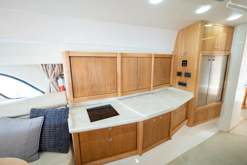 Slide: The Image of Luxurious 2018 Intrepid 475 Sport Yacht interior with modern kitchen and wooden cabinetry. - 130