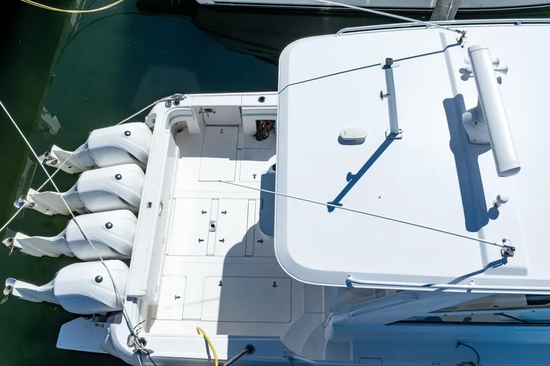 Slide: The Image of 2018 Intrepid 475 Sport Yacht with four outboard engines, docked in clear water. - 23