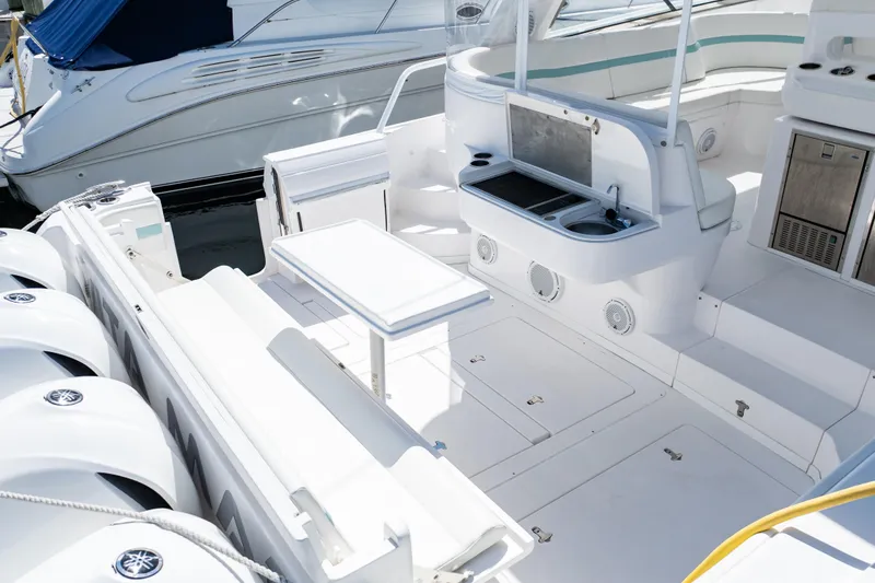 Slide: The Image of 2018 Intrepid 475 Sport Yacht deck with seating, table, and outdoor kitchen area. - 30
