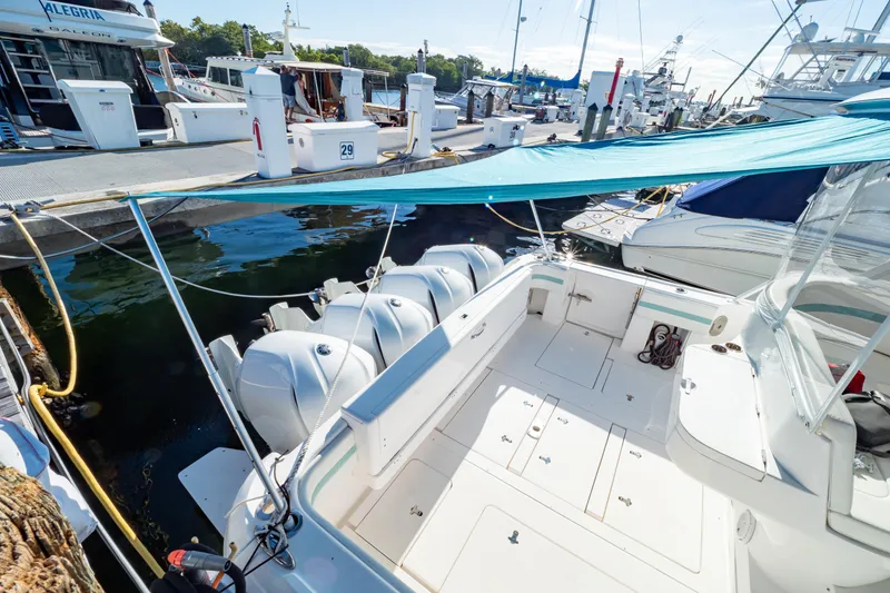 Slide: The Image of 2018 Intrepid 475 Sport Yacht docked, featuring spacious deck and multiple outboard engines. - 37