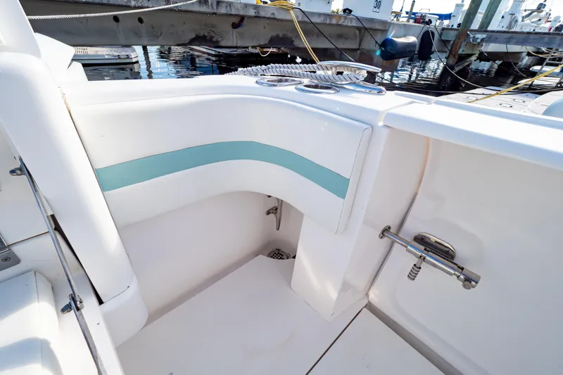 Slide: The Image of 2018 Intrepid 475 Sport Yacht interior with white and teal seating, docked at marina. - 40