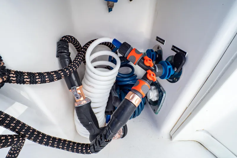 Slide: The Image of 2018 Intrepid 475 Sport Yacht water hose connections and fittings in storage compartment. - 42
