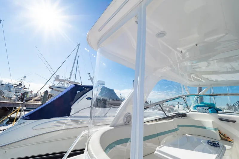 Slide: The Image of 2018 Intrepid 475 Sport Yacht docked under bright sun, showcasing sleek design and spacious deck. - 69