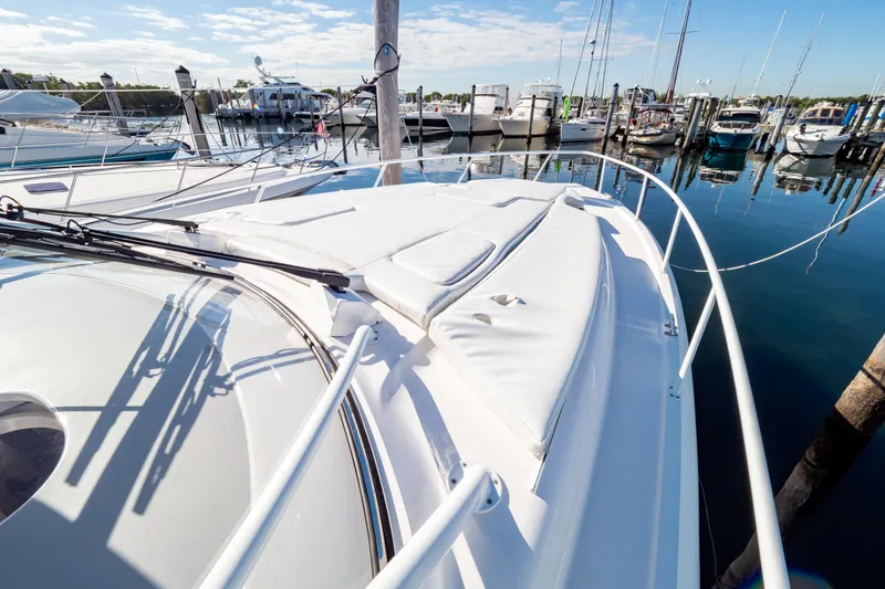 Slide: The Image of 2018 Intrepid 475 Sport Yacht docked at marina, showcasing sleek design and spacious deck. - 77