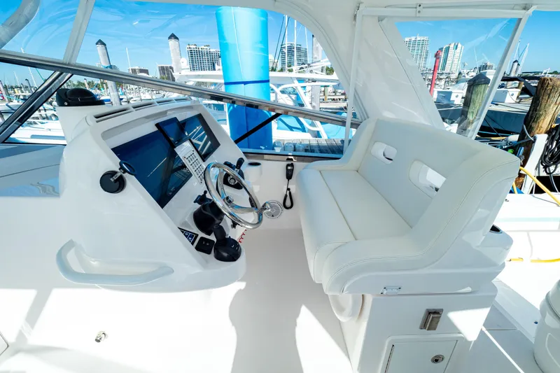 Slide: The Image of Helm of 2018 Intrepid 475 Sport Yacht with modern controls and white seating. - 85