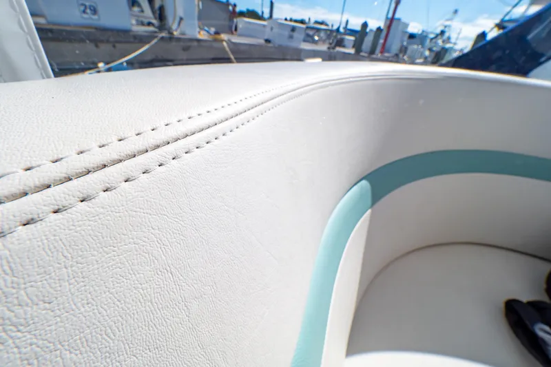 Slide: The Image of Close-up of 2018 Intrepid 475 Sport Yacht's white leather seating with teal accents. - 93