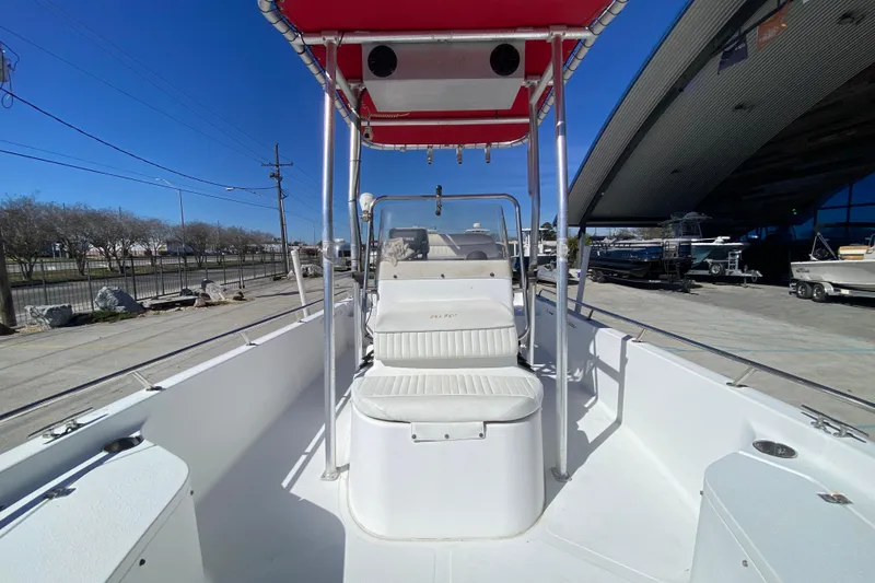 Slide: The Image of 2005 Sea Pro SV2400CC Bay Boat with red canopy, docked under clear blue sky. - 19