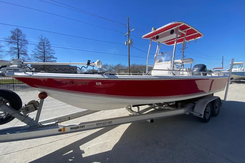 Slide: The Image of 2005 Sea Pro SV2400CC Bay Boat in red on trailer, clear blue sky background. - 7
