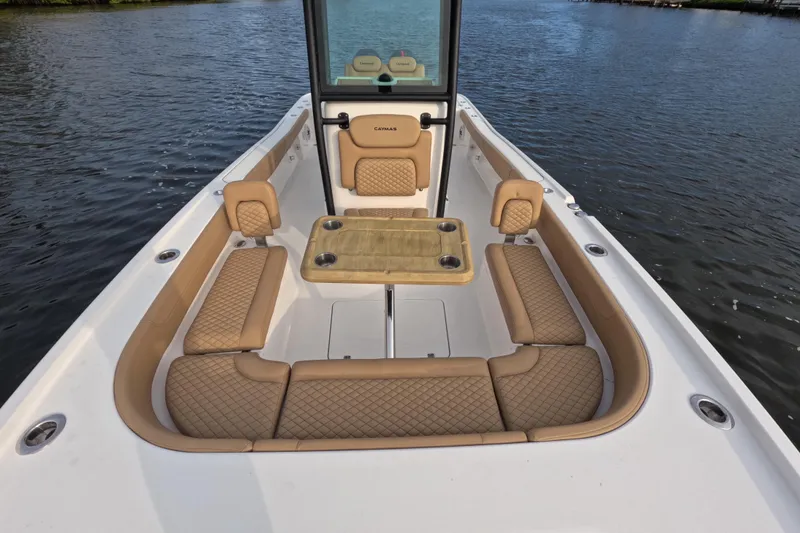 Slide: The Image of 2024 Caymas 281 HB boat interior with tan seating and table on water. - 11