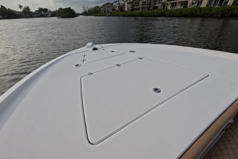 Slide: The Image of 2024 Caymas 281 HB boat deck on calm waterway, surrounded by lush greenery. - 18