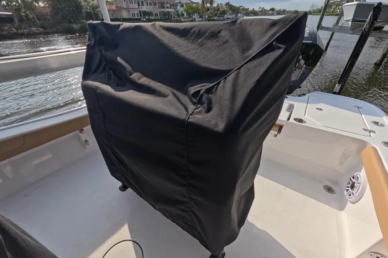 Slide: The Image of 2024 Caymas 281 HB boat with covered console, docked by waterfront homes. - 28