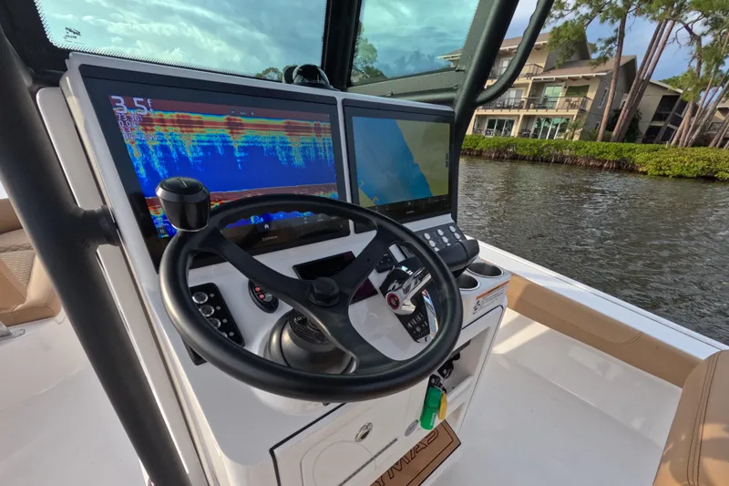 Slide: The Image of 2024 Caymas 281 HB boat dashboard with dual navigation screens and steering wheel. - 6