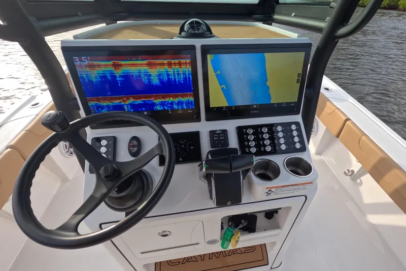 Slide: The Image of 2024 Caymas 281 HB boat dashboard with dual navigation screens and steering wheel. - 7