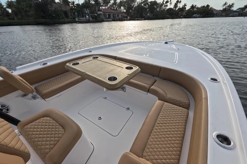 Slide: The Image of Luxurious 2024 Caymas 281 HB boat interior with tan seating and table on calm water. - 9