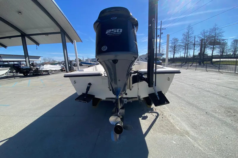 Slide: The Image of 2001 Pathfinder 2400 V boat with 250 horsepower engine, parked outdoors under clear sky. - 4