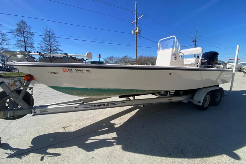 Slide: The Image of 2001 Pathfinder 2400 V boat on trailer, parked outdoors under clear blue sky. - 7