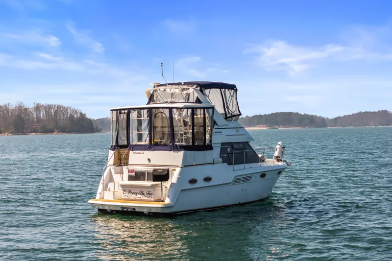 The Image of 2000 Carver 326 Aft Cabin Motor Yacht on serene lake with clear blue sky. - 0