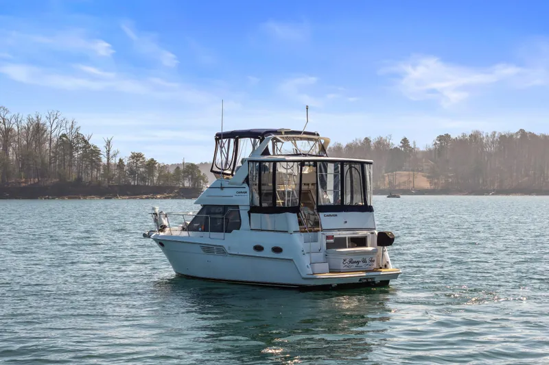 Slide: The Image of 2000 Carver 326 Aft Cabin Motor Yacht on serene lake with wooded shoreline. - 3