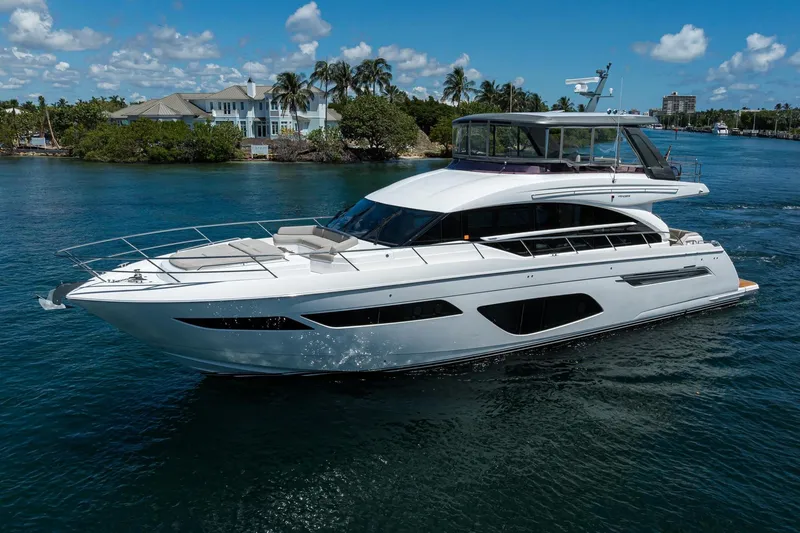 Slide: The Image of Luxurious 2020 Princess F70 yacht cruising on a sunny day near waterfront homes. - 5