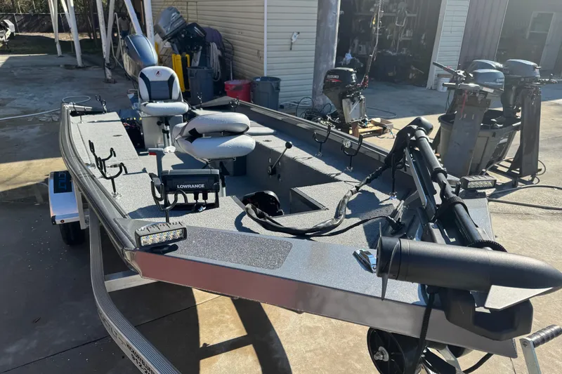Slide: The Image of 2018 Alumacraft Crappie Deluxe fishing boat with equipment and accessories in a garage setting. - 12