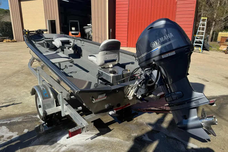 Slide: The Image of 2018 Alumacraft Crappie Deluxe boat with Yamaha motor on trailer, parked outside. - 3