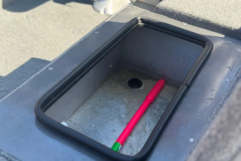 Slide: The Image of 2018 Alumacraft Crappie Deluxe boat storage compartment with a pink fishing rod. - 7