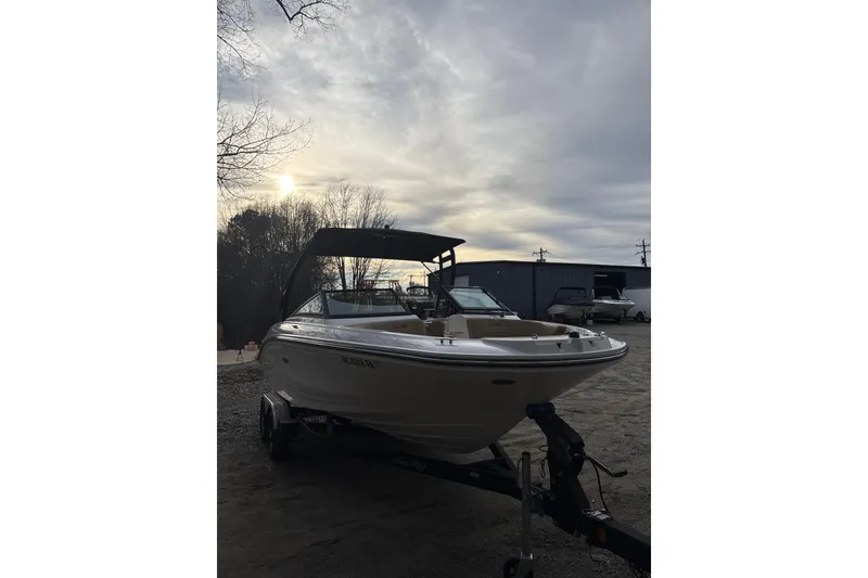 Slide: The Image of 2023 Sea Ray SPX 210 boat on trailer under cloudy sky. - 10