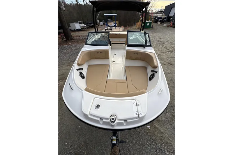 Slide: The Image of 2023 Sea Ray SPX 210 boat with tan seating, parked on gravel. - 12