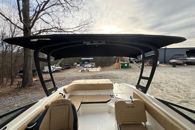 Slide: The Image of 2023 Sea Ray SPX 210 boat interior with canopy, parked outdoors. - 17