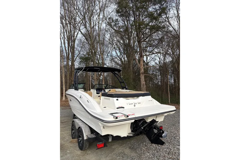 Slide: The Image of 2023 Sea Ray SPX 210 boat on trailer, parked in wooded area. - 5