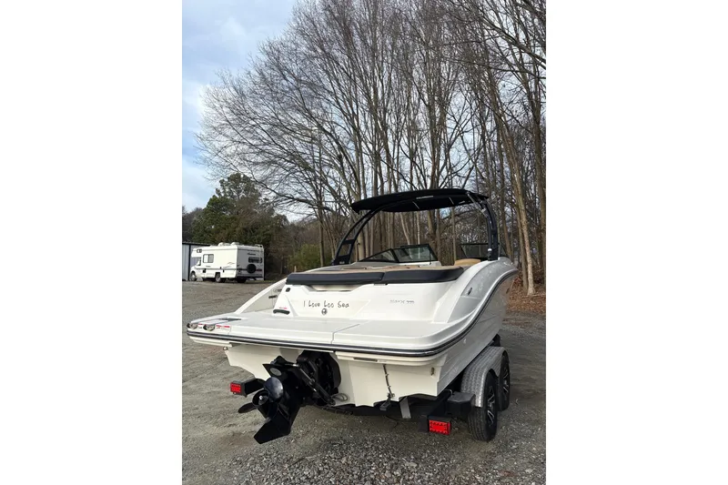 Slide: The Image of 2023 Sea Ray SPX 210 boat on trailer, parked near trees and RV. - 7