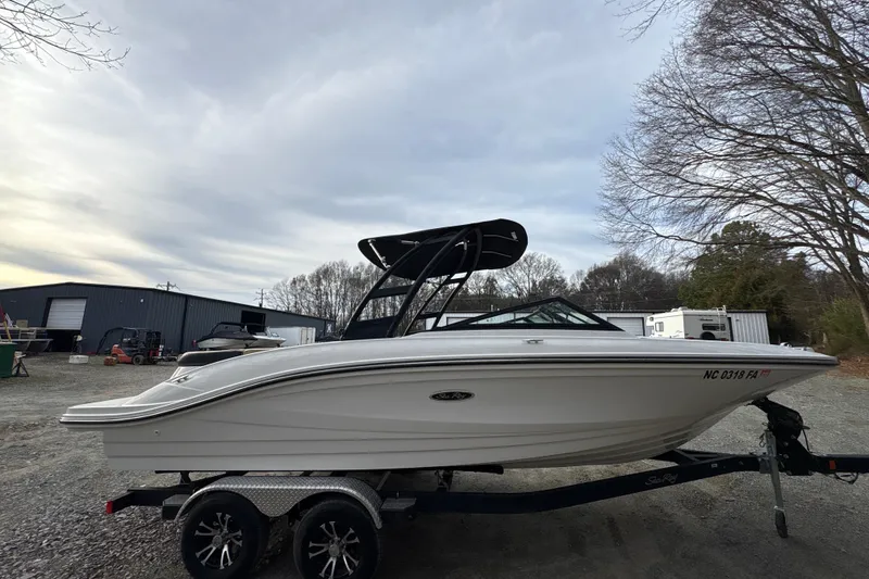 Slide: The Image of 2023 Sea Ray SPX 210 boat on trailer, parked outdoors under cloudy sky. - 8