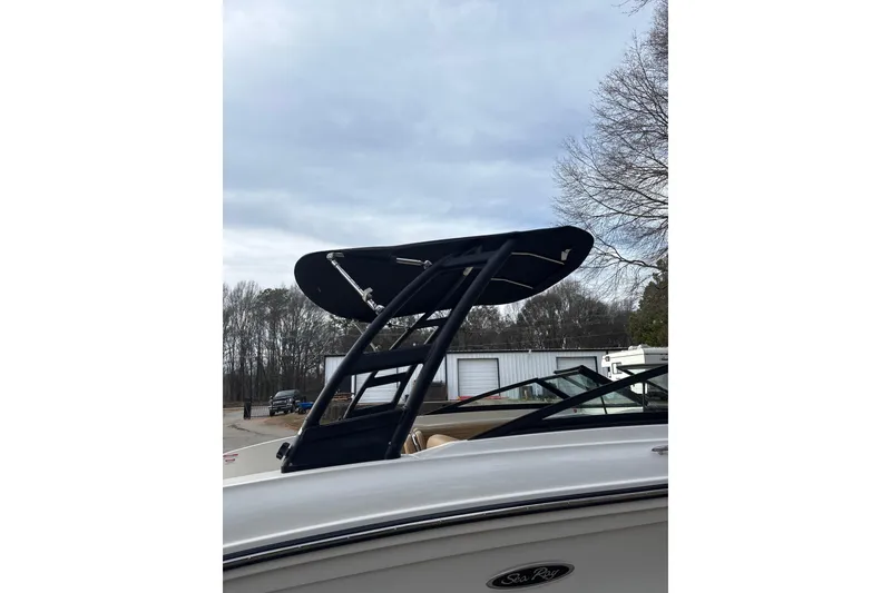 Slide: The Image of 2023 Sea Ray SPX 210 boat with a sleek black wakeboard tower against a cloudy sky. - 9