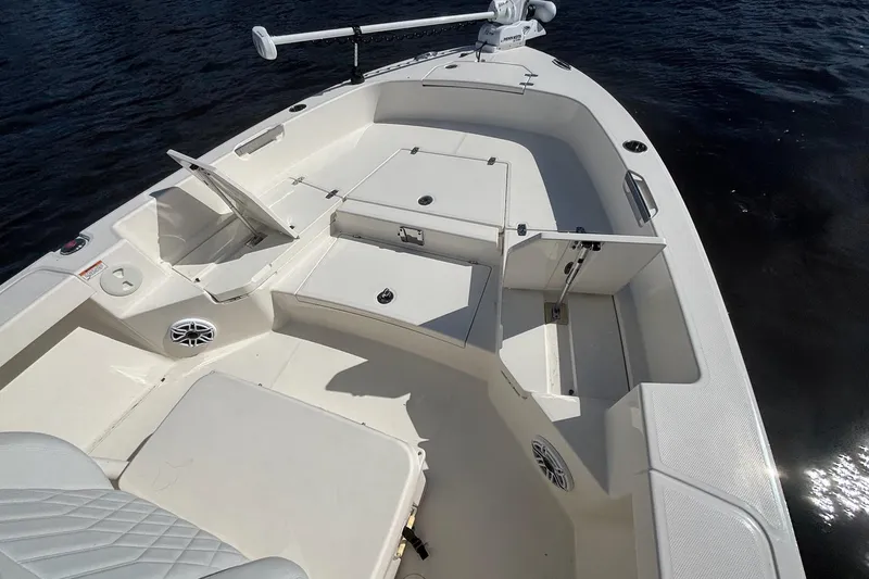 Slide: The Image of 2023 Pathfinder 2400 TRS boat interior with open storage compartments on calm water. - 10
