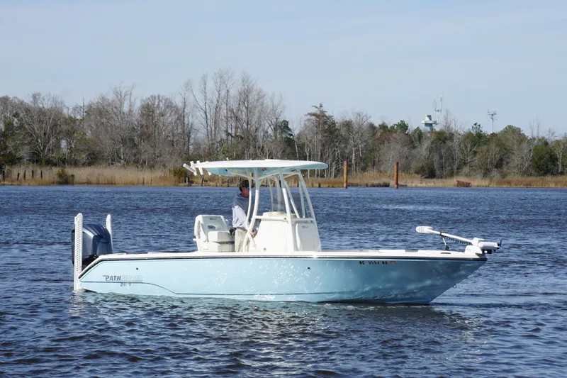 Slide: The Image of 2023 Pathfinder 2400 TRS boat on a calm lake with trees in the background. - 3