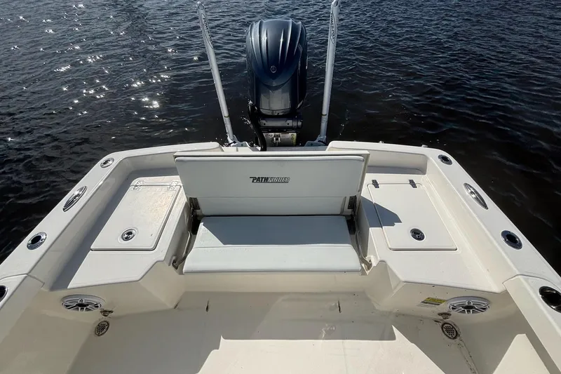 Slide: The Image of 2023 Pathfinder 2400 TRS boat stern view with seating and motor on water. - 8