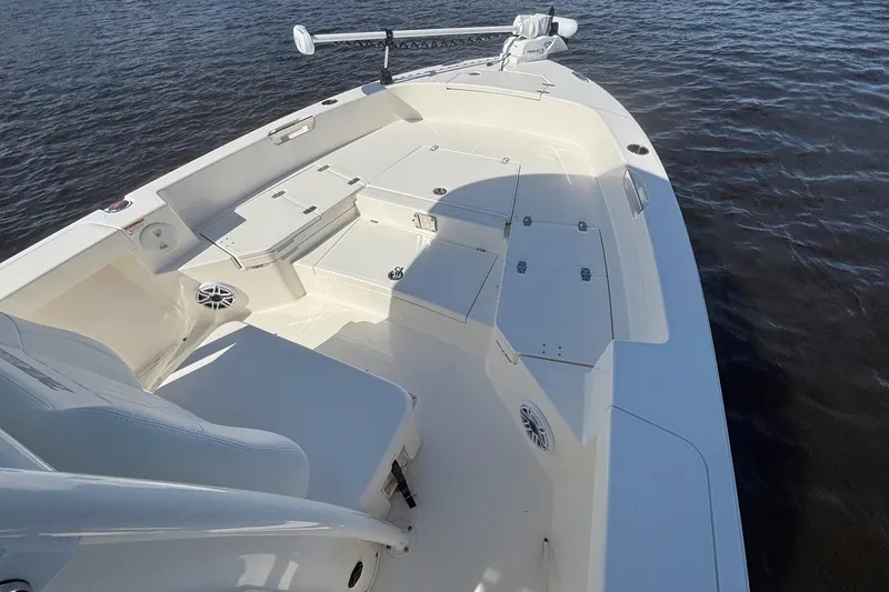 Slide: The Image of 2023 Pathfinder 2400 TRS boat deck with seating and storage on calm water. - 9