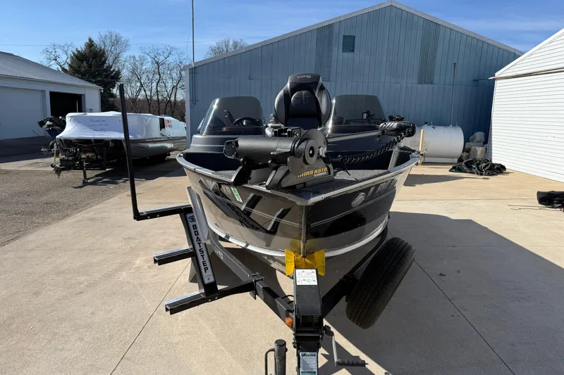 Slide: The Image of 2014 Lund 1875 Impact SS boat on trailer, parked outdoors near blue building. - 2