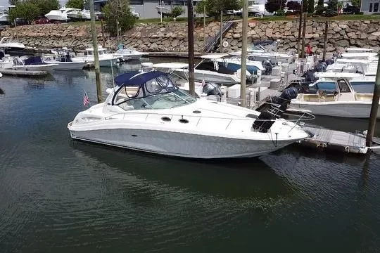 The Image of 2008 Sea Ray 340 Sundancer yacht docked at marina, featuring sleek design and dark canopy. - 0